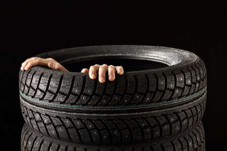 Hands hold a rubber tyre cover from withinの写真素材