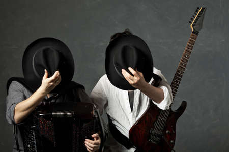 Two musicians with a guitar and an accordion close the face hatsの写真素材