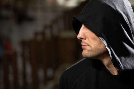 Profile of the man in a hood on a black background      の写真素材