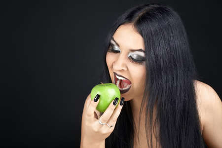 Brunette eating a green appleの写真素材