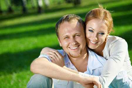 Laughing young couple embraces in a summer gardenの写真素材