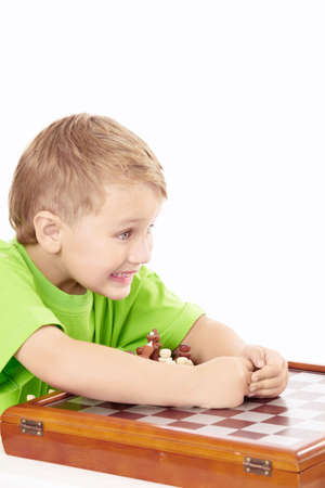 Exulting little boy has won a chess set, isolatedの写真素材