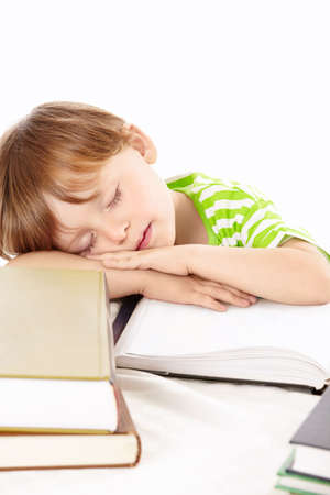 Little boy sleeps on a heap of the books, isolatedの写真素材