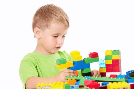 Little boy builds something of the plastic multi-coloured parts, isolated
の写真素材