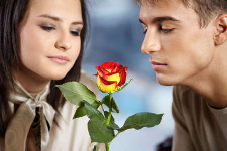 Pair in cafe - man and woman smell a roseの写真素材