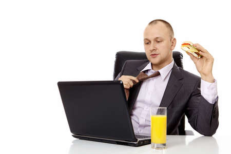 The young businessman has a bite behind the laptopの写真素材