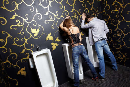 Drunk man and the woman in a night club toiletの写真素材