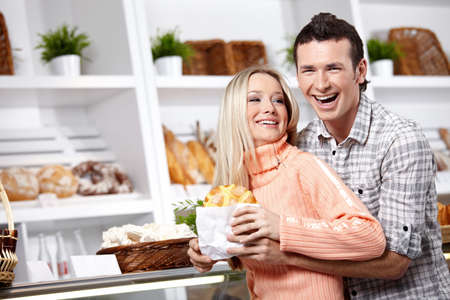 Embracing young couple in a baker's shopの写真素材