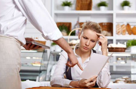 The attractive girl chooses a dish in cafeの写真素材