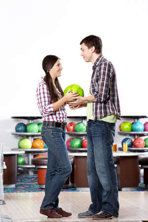 The young man gives a sphere for bowling to the girlの写真素材