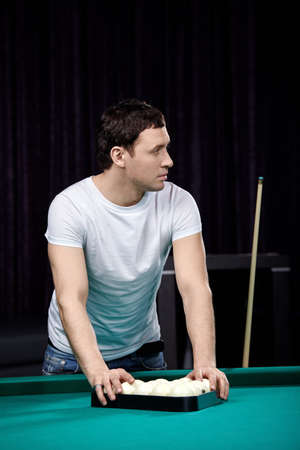 The young attractive man is going to play billiards