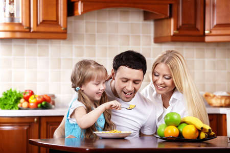 The young family has breakfast with the child on kitchenの写真素材