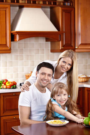 Happy family in kitchen look in cameraの写真素材
