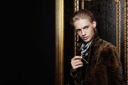 The young man hides a key from a door in a pocketの写真素材