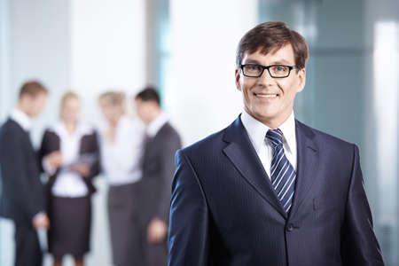 Business man in office compared to other staffの写真素材