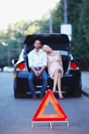 Young couple in a car with a red triangle in the foreground