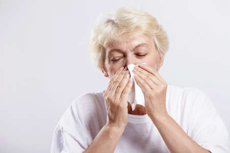 An elderly woman with a handkerchief on a white backgroundの写真素材