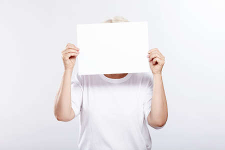 An elderly woman with an empty plate from a person on a white backgroundの写真素材