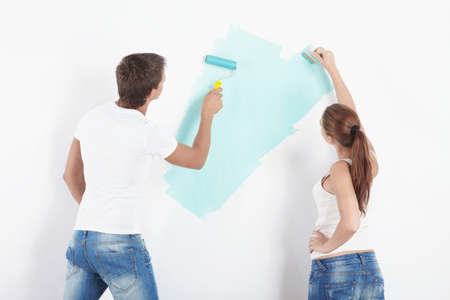 Young couple paint the walls in the apartmentの写真素材