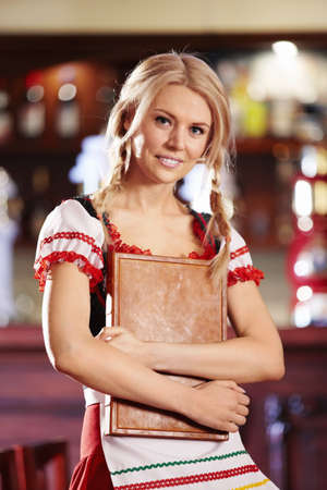 A pretty young waitress holding menu in his handの写真素材