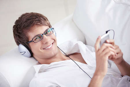 Smiling man listening to music on headphonesの写真素材