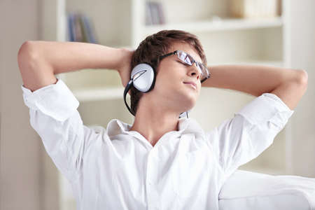 A man listens to music on headphones at homeの写真素材