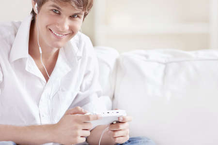 A man with headphones playing consoleの写真素材