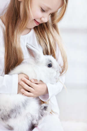 Beautiful little girl holding a funny bunnyの写真素材