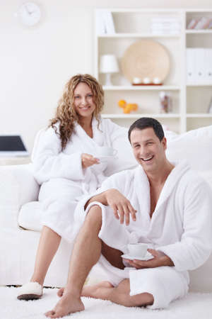 Young attractive couple drinking coffee at homeの写真素材
