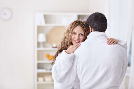 Embracing a married couple in dressing gownsの写真素材