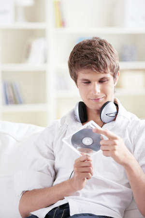 A young man holds a music CDの写真素材