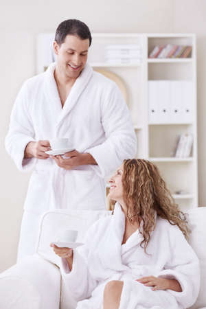 Happily married couple in dressing gowns at homeの写真素材