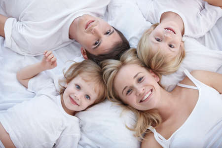 Young families with children on the bedの写真素材