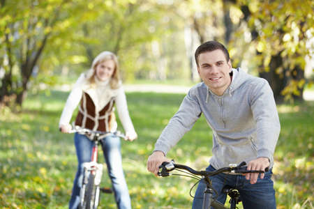 A young man on a bicycle in the foregroundの写真素材