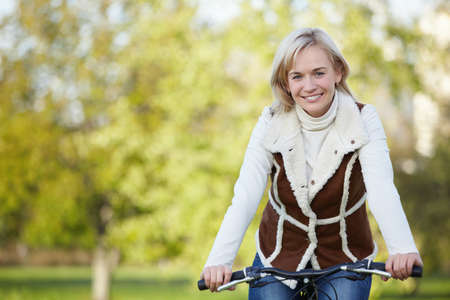 Attractive young girl on a bicycle in the parkの写真素材
