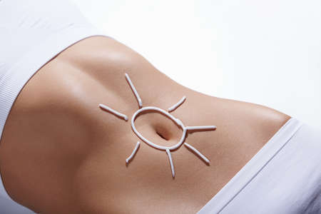 Image of the sun on the belly of a young girlの写真素材
