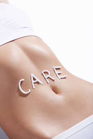 The word "care" in the abdomen of a young girlの写真素材