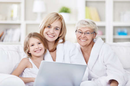 Portrait of three generations of women with a laptopの写真素材