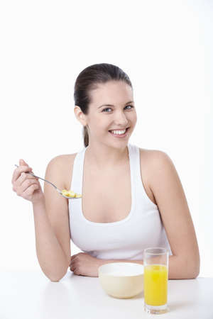 Young attractive girl breakfast corn flakes on a white backgroundの写真素材