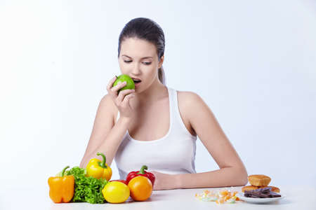 The girl is the apple and looks for dessert on a white backgroundの写真素材