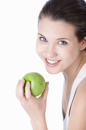 Young beautiful girl holding a green Apple on a white backgroundの写真素材
