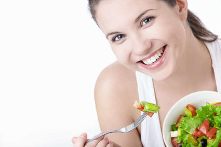 Smiling girl with a salad on a white backgroundの写真素材
