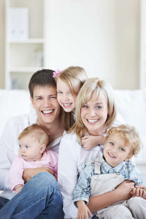 Attractive family with three children at homeの写真素材