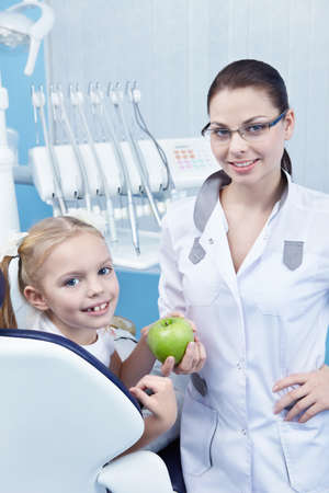 Dentist gives the child a green Appleの写真素材