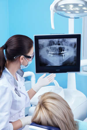 Dentist shows a patient x-ray