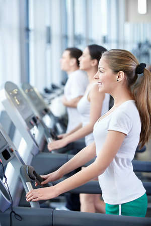 Happy young people on treadmillsの写真素材