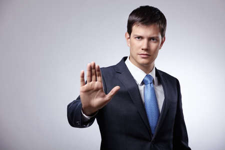 Young businessman in a suit shows his handの写真素材