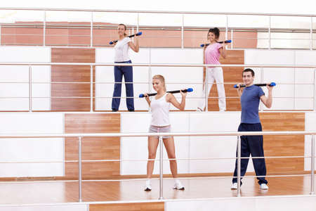 Attractive young people doing exercises in the fitness clubの写真素材