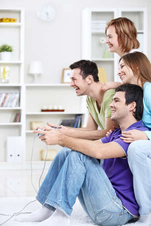 Young friends playing video games at home