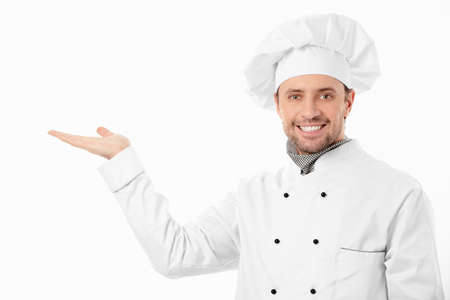 A smiling cook shows his hand on a white backgroundの写真素材